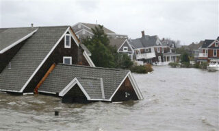 A street view of two-story homes that seem to be floating in flood waters from Hurricane Sandy