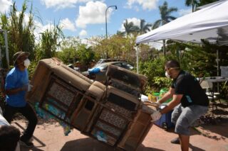 Two men carrying a sofa.