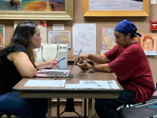 Two women working together at a table in a library
