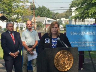 Sue Marticek at a podium outdoors with Senator Menendez